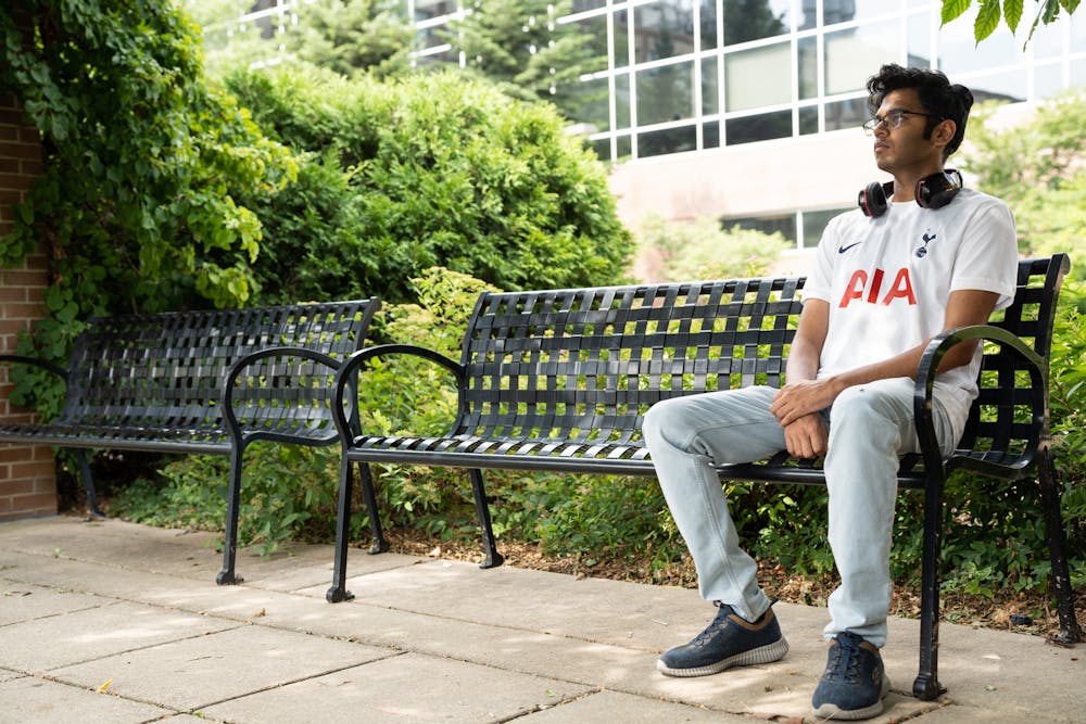 <p>Agrim Gupta sits outside Michigan State&#x27;s Biomedical and Physical Sciences building on July 14, 2022. Gupta conducts astrophysics research in the building as a summer job.</p><p></p><p>His jersey was special made with his name on the back, saluting his favorite soccer team, the Tottenham Hotspur.</p>