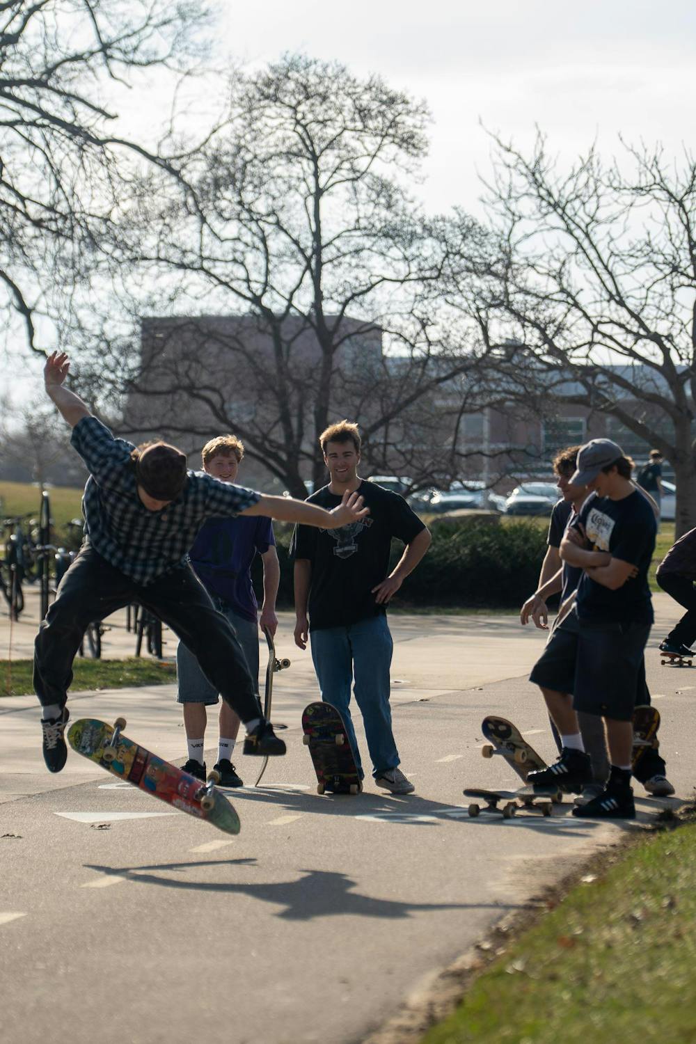 Members of MSU Skate Club talk and wait as others take turns practicing tricks during skate club outside of Shaw Hall on Michigan State University’s campus in East Lansing, Mich., on March 20, 2026.