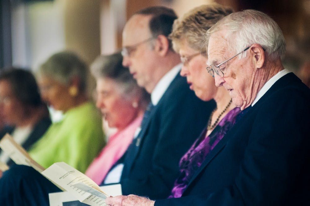 Attending the memorial service of former MSU provost Clarence Leland Winder, John Cantlon, who also served as a provost, sings along to a hymn beside the immediate family of Winder on Saturday, Aug. 11, 2012 at the Burcham Hills Retirement Community, 2700 Burcham Drive. Adam Toolin/The State News