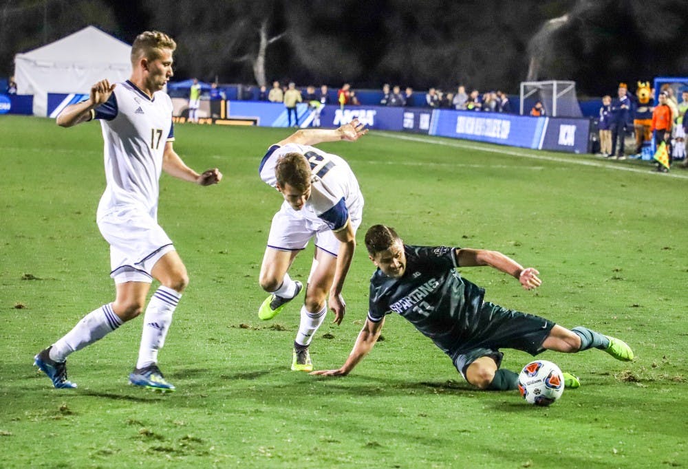 <p>Then senior forward Ryan Sierakowski (11) slides to keep the ball away from the defenders during the game against Akron on Dec. 7, 2018 at Harder Stadium. The Spartans fell to the Zips 5-1.</p>