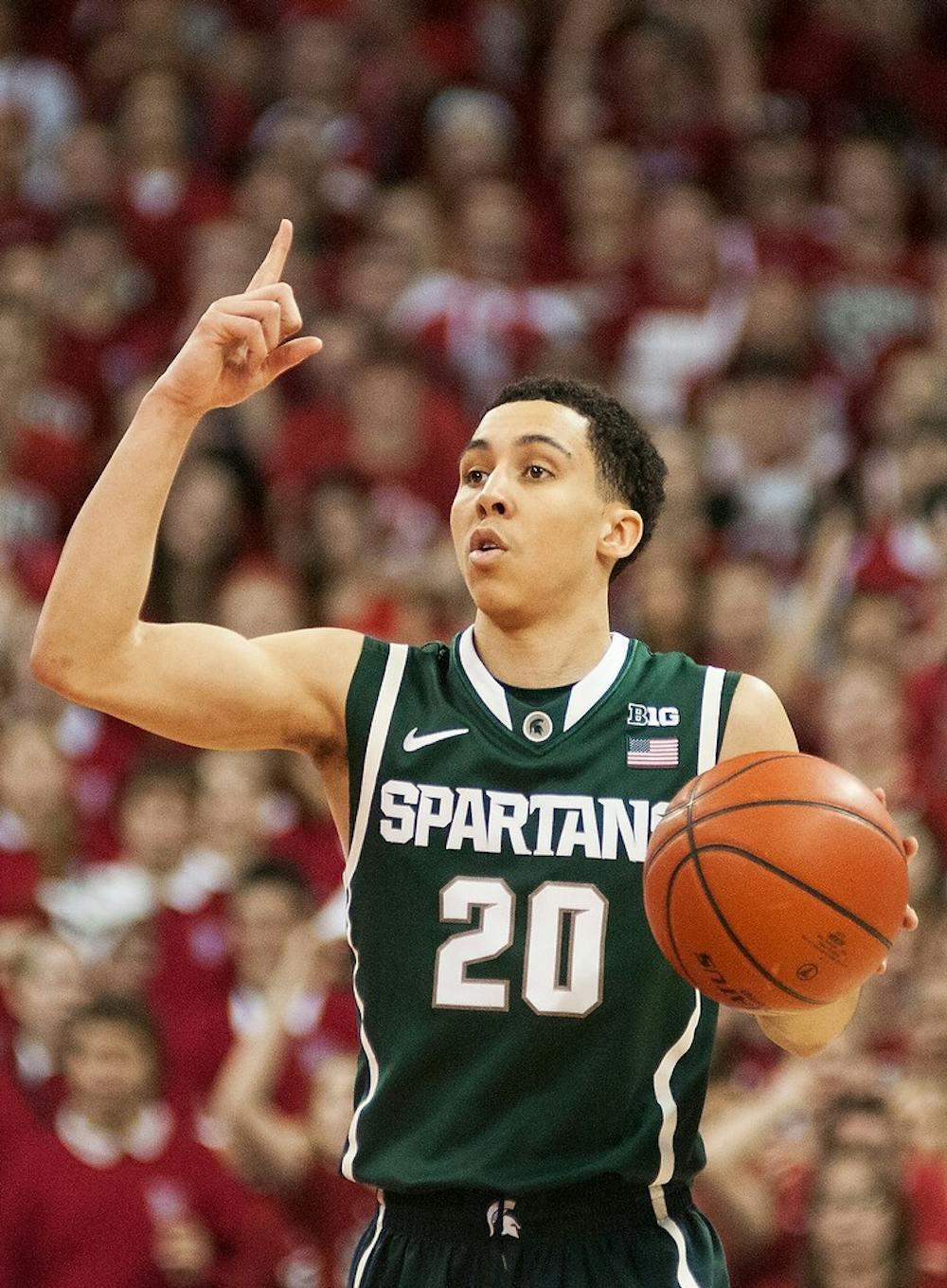 	<p>Junior guard Travis Trice motions to teammates during the game against Wisconsin on Feb. 9, 2014, at Kohl Center in Madison, Wis. The Spartans lost to the Badgers, 60-58. Danyelle Morrow/The State News</p>