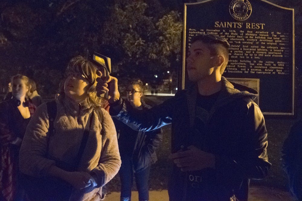 International relations senior Jared Gajos uses a temperature gun in an attempt to detect paranormal activity on Oct. 20, 2016 near Beaumont Tower. MSU Campus Archaeology Program and MSU Paranormal Society put on a tour to show some of the supposed haunted spots on campus.  