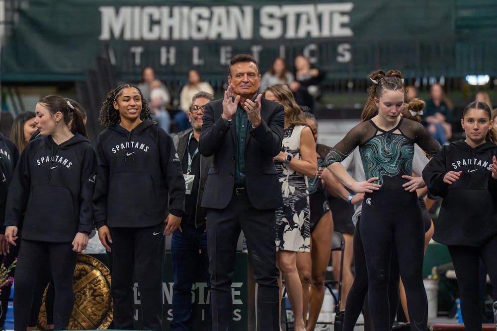 <p>Michigan State head coach Mike Rowe claps as gymnasts perform their floor routines during Michigan State’s meet against Brown at Jenison Field House in East Lansing, Mich., on Sunday, March 15, 2026.</p>