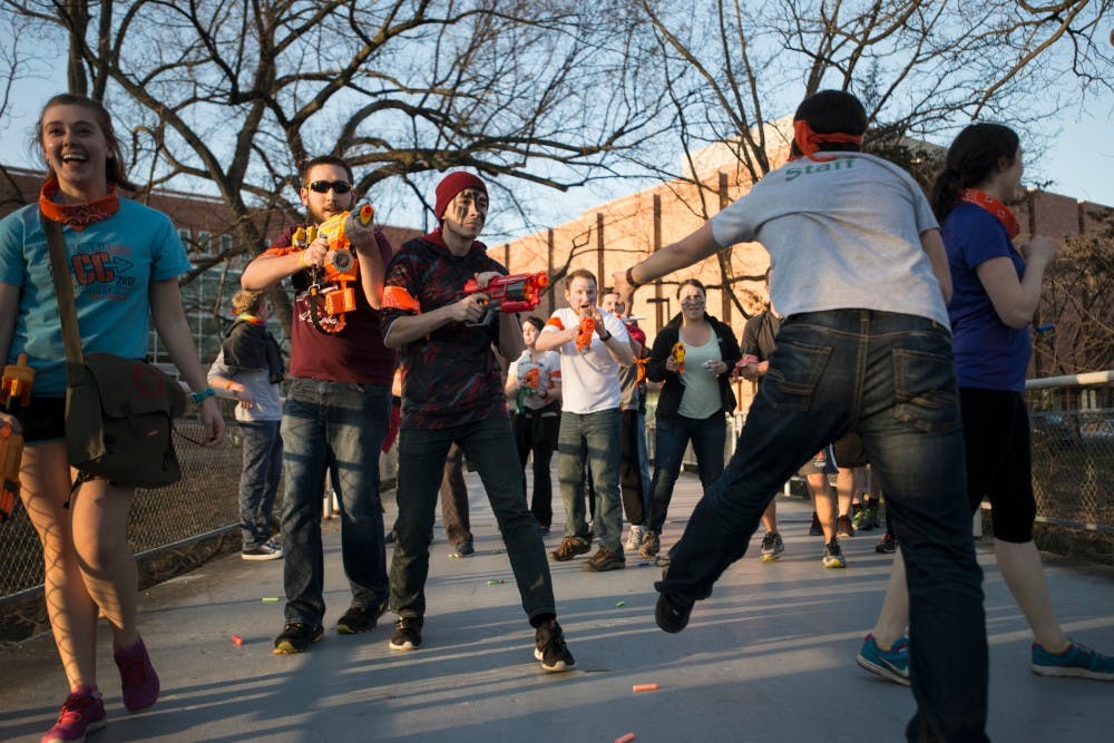 MSU alumnus Ben Blaut, left, and computer science sophomore Diego Carrillo fight off a zombie during Spartans vs. Zombies on April 14, 2016 outside of the Main Library.