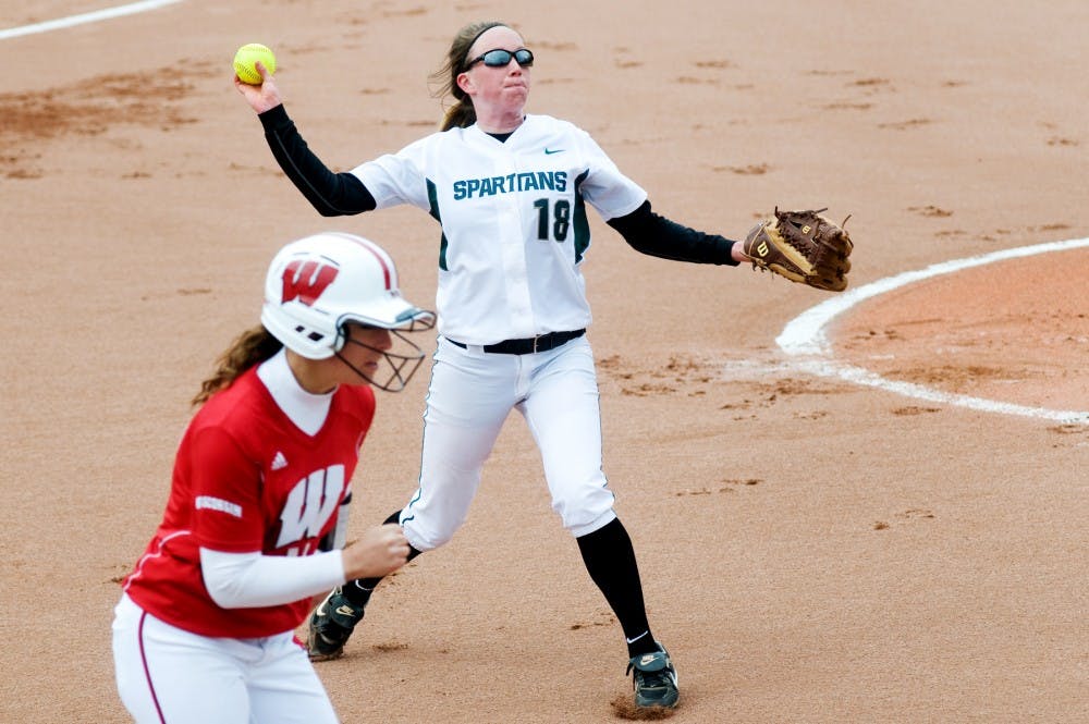 Freshman pitcher Cassee Layne throws the ball to first base after Wisconsin outfielder Kendall Grimm made a hit during Saturday's game at Secchia Stadium. It was the first game to be played at the stadium. Lauren Wood/The State News