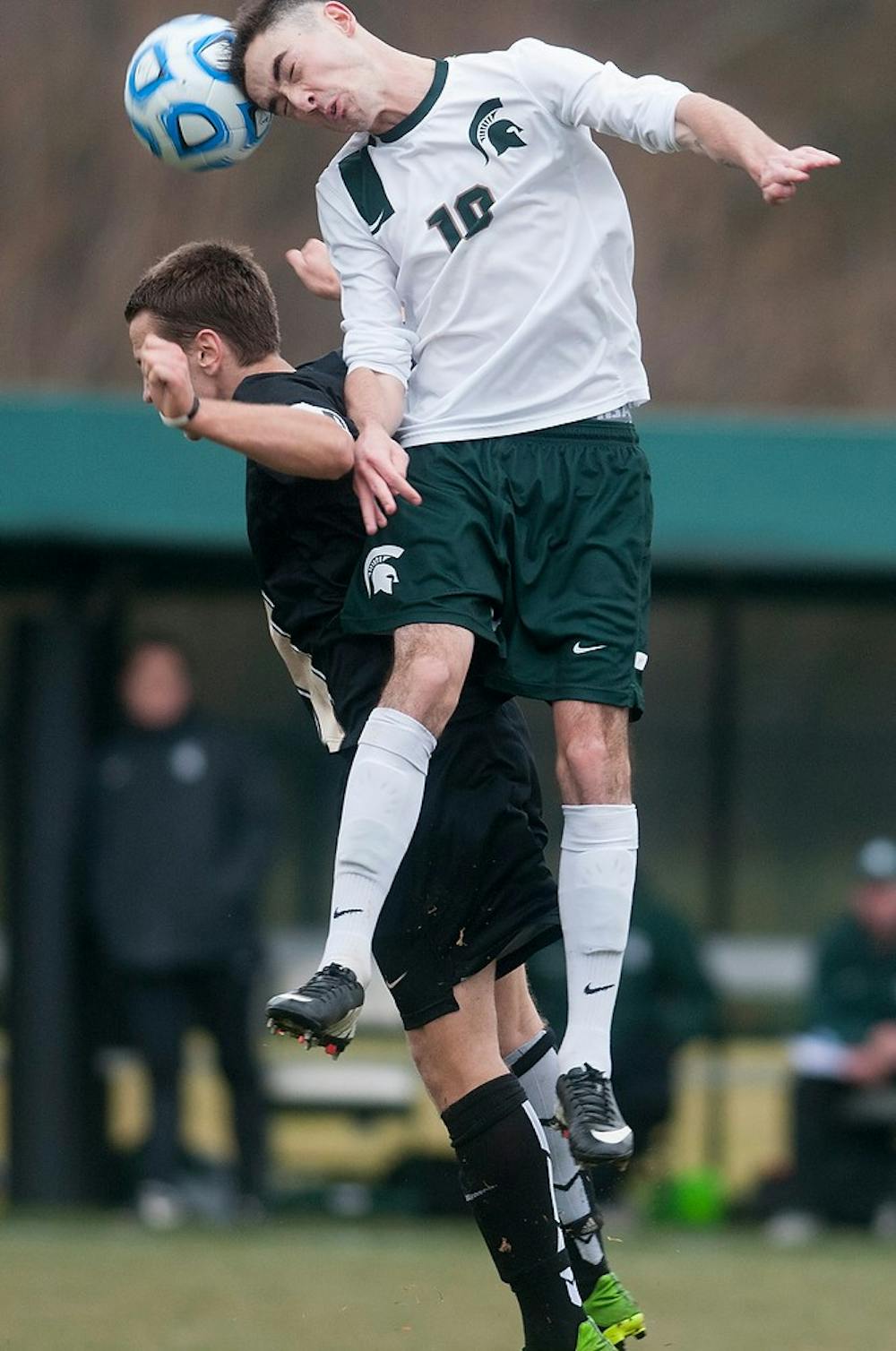 <p>Junior midfielder Jay Chapman heads the ball as Oakland midfielder Derek Nowak defends Nov. 23, 2014, during the game against Oakland at DeMartin Stadium at Old College Field. The Spartans defeated the Golden Grizzlies, 1-0. Aerika Williams/The State News </p>