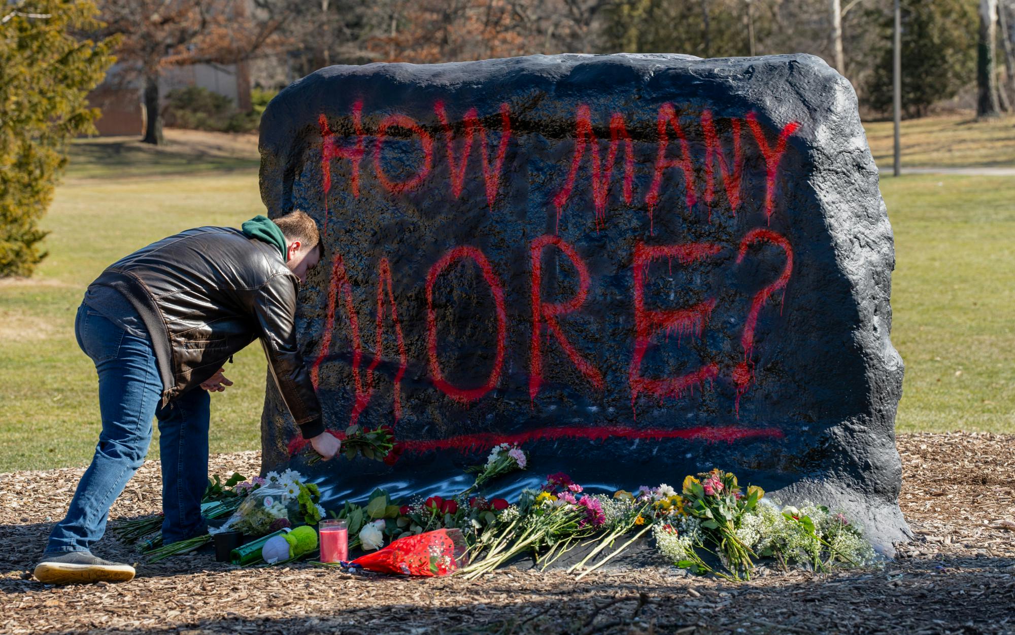 <p>Political science senior Caleb Christensen delivers flowers to The Rock on Farm Lane on Feb. 14, 2023, one day after the mass shooting in Michigan State University's North Neighborhood.</p>
