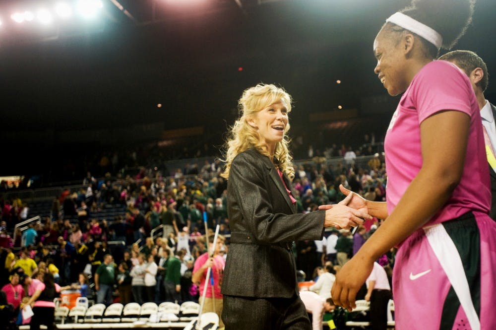 Head coach Suzy Merchant about to exchange a hug with senior guard Porsch? Poole, whose last-minute 2-point field goal helped the Spartans to defeat the Michigan Wolverines, 65-63, Sunday afternoon at Crisler Arena. Justin Wan/The State News