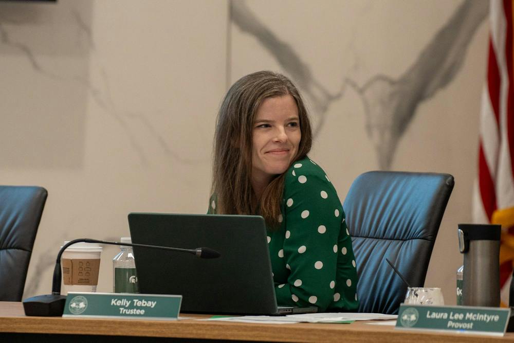 <p>MSU Trustee Kelly Tebay smiles at another board member during the MSU Board of Trustees meeting in East Lansing, Mich., on Sept. 11, 2026.</p>