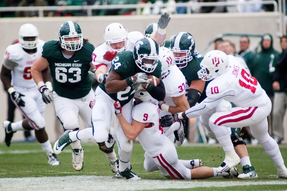 Sophomore Le'Veon Bell carries the ball as he is tackled by Indiana defense during Saturday's game in Spartan Stadium. Bell rushed for 68 yards. Lauren Wood/The State News