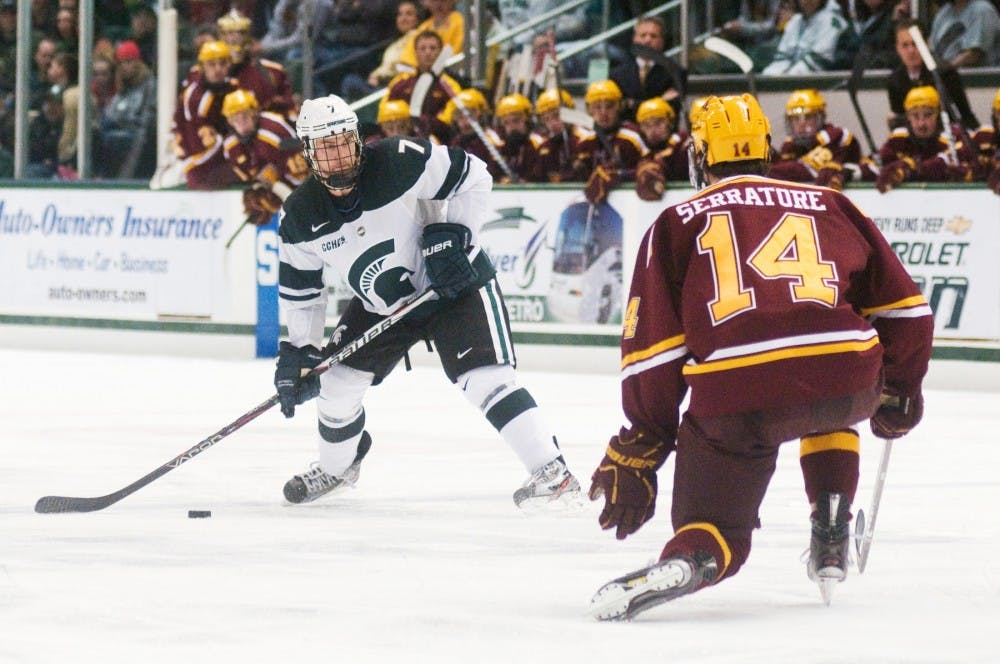 Senior defender Tim Buttery sets up a pass as Minnesota forward Tom Serratore slides in to block it Friday evening at Munn Ice Arena. The Spartans defeated the Golden Gophers 4-3. Matt Radick/The State News