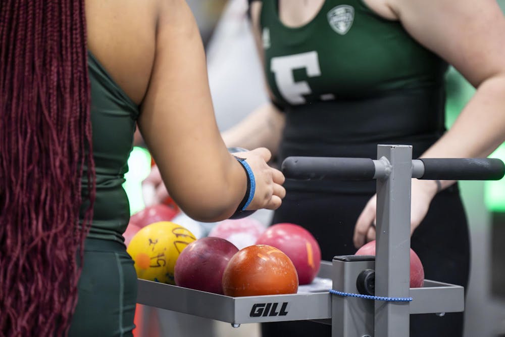 <p>Players pick up weighted balls for the shot put event at the Silverston Invitational track and field competition held in Ann Arbor, Mich. on Feb. 20, 2026.&nbsp;</p>