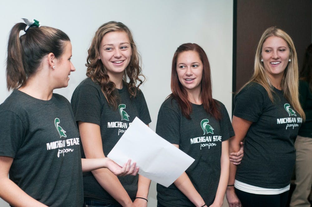 Members of the Pompon team teach international students the fight song during a Life in the U.S. Culture series session on sports on Thursday,  Sept. 27, 2012 at the International Center. Various cheers were also taught to the international students in attendance. Julia Nagy/The State News