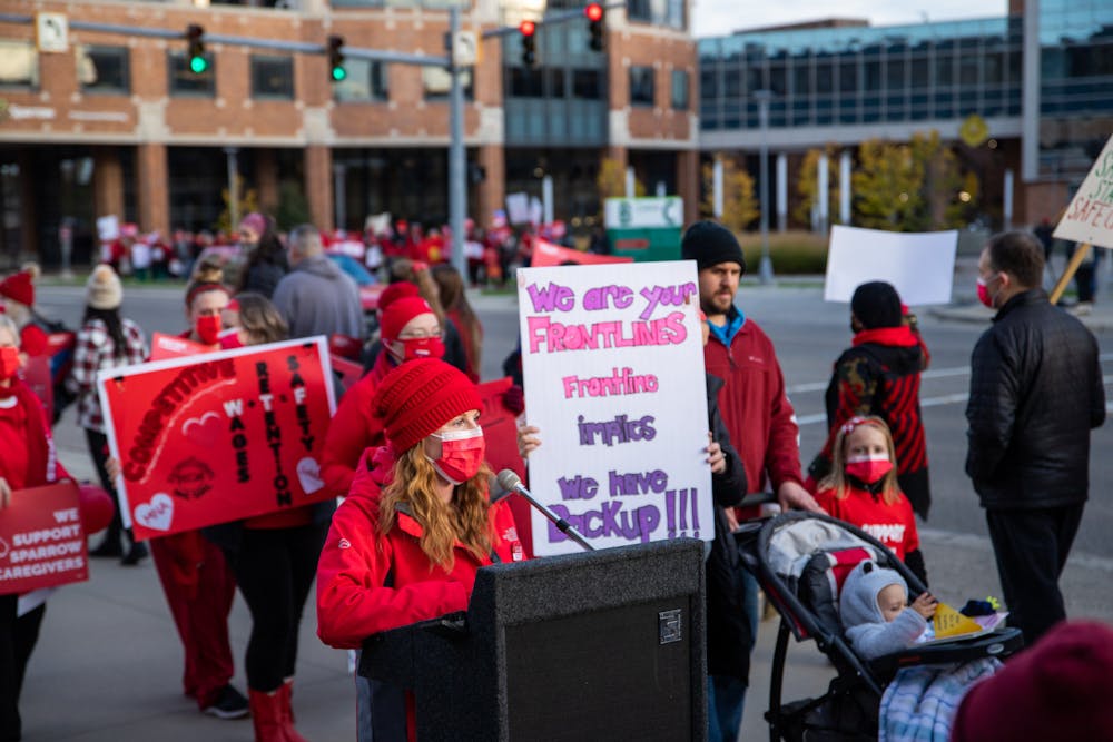 <p>Sparrow nurses along with supporters of them picket along Michigan Avenue in Lansing on Nov. 3, 2021. The picket was organized by the Professional Employees Council of Sparrow Hospital-Michigan Nurses Association, and shown is PECSH President and Sparrow nurse, Katie Pontifex, speaking at the event. </p>