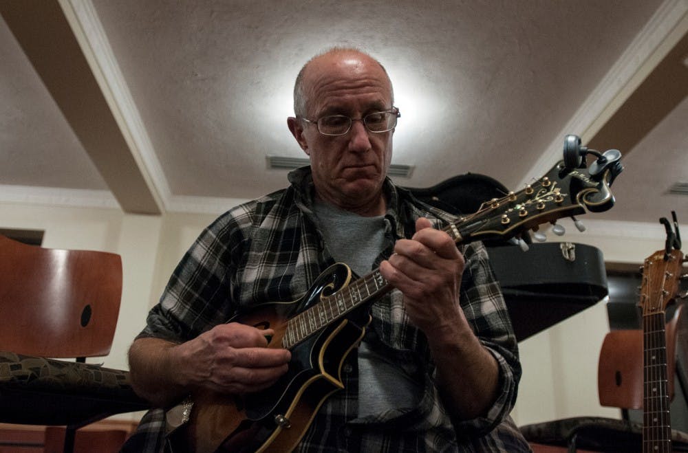 John Suppnick plays along with fellow folk musicians on Nov. 22, 2016 at Snyder Hall. The musicians include students, professors, and people from around the area who gather weekly to play folk music.