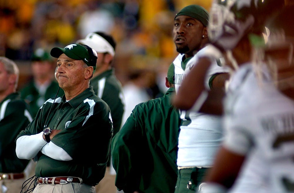 <p>An injured Matt Trannon stands behind Head Coach John L. Smith as the clock winds down on MSU hopes of beating of Michigan on Oct. 7, 2006. The Spartans lost, 31-13. Katie Rausch/The State News</p>