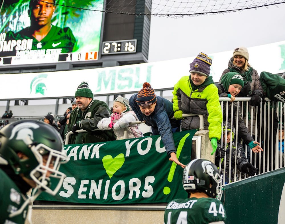 Spartan fans high five players during the Senior Day game on Nov. 30, 2019 at Spartan Stadium. The Spartans beat the Terrapins 19-16.