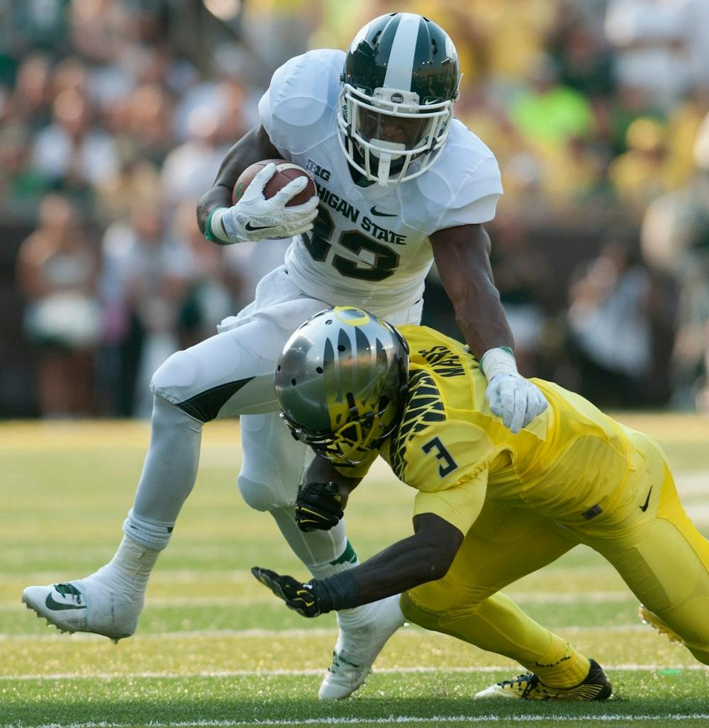 <p>Oregon defensive back Dior Mathis tackles senior running back Jeremy Langford on Sept. 6, 2014, at Autzen Stadium in Eugene, Ore. The Spartans lost to the Ducks, 46-27. Julia Nagy/The State News</p>