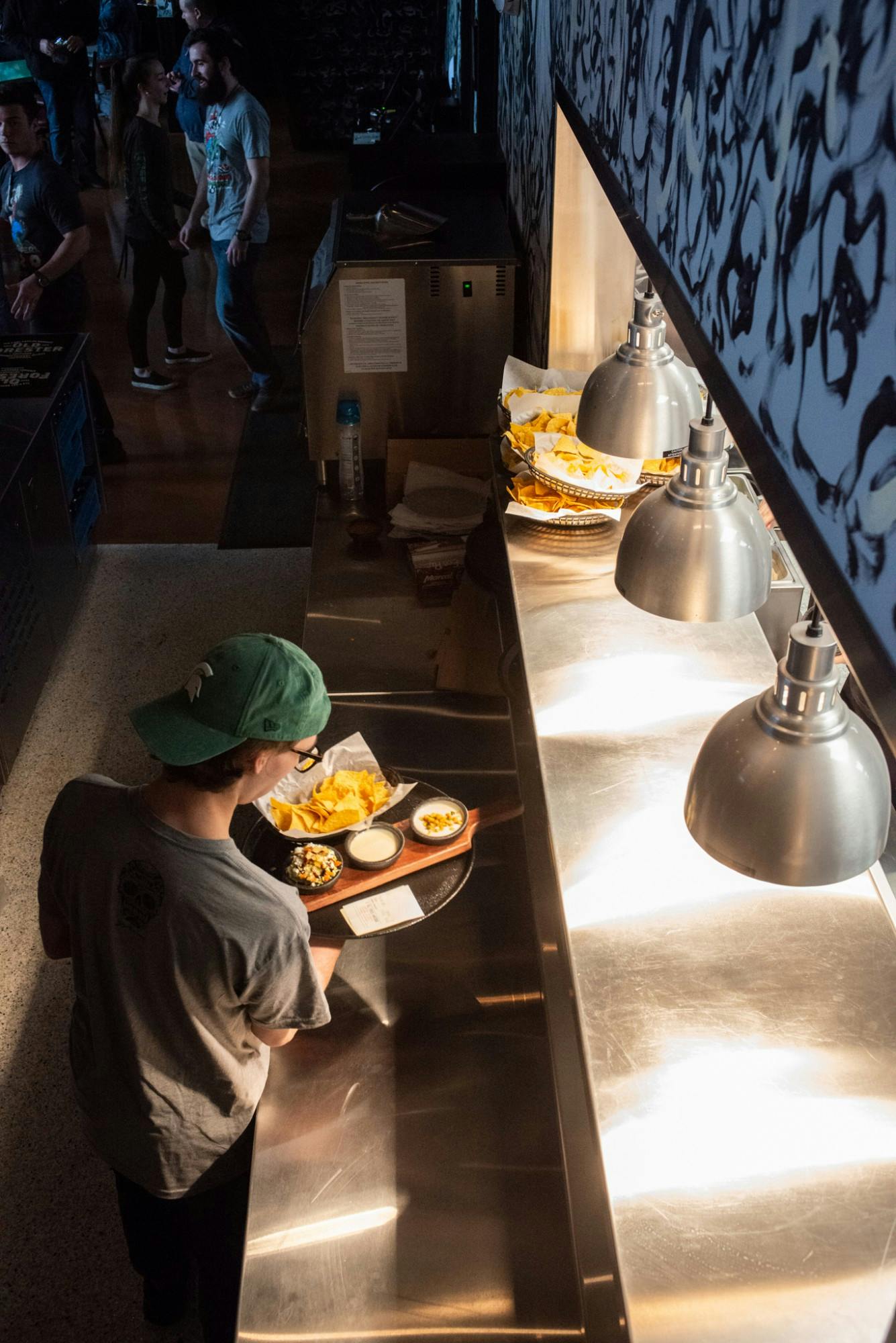 Server Alec Gerstenberger picks up an order from the kitchen during Barrio’s grand opening on March 9, 2020.