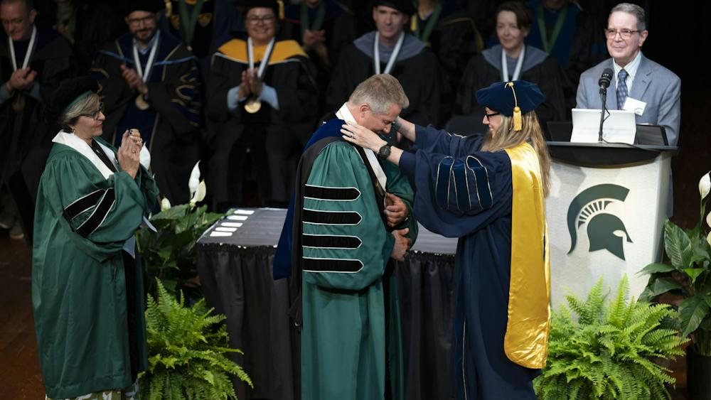 MSU Provost Laura Lee McIntyre places a medallion around the neck of MSU President Kevin M. Guskiewicz during the 2026 State of the University Address at the Pasant Theatre in the Wharton Center for Performing Arts at MSU on Tuesday, Sep 29, 2026.