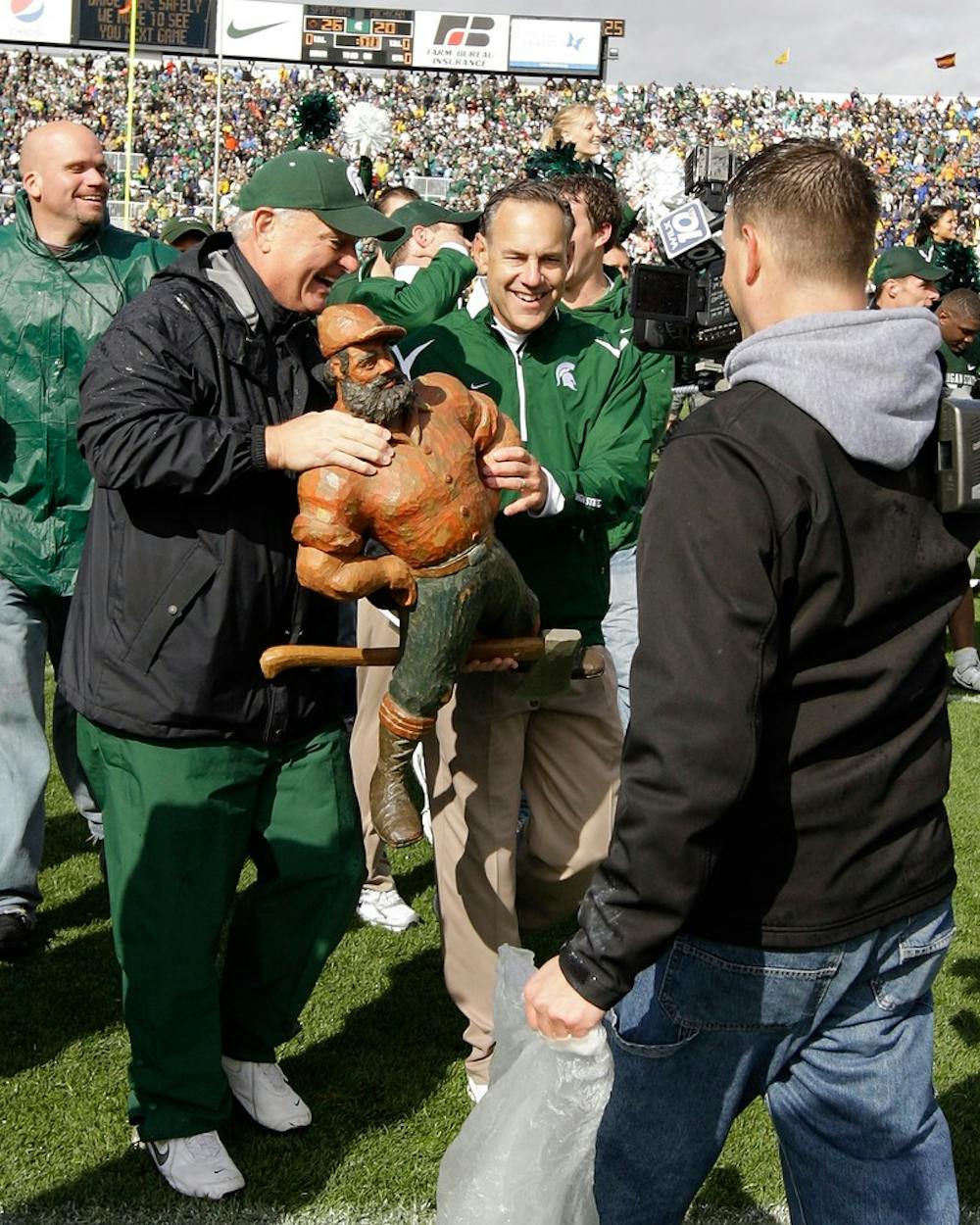 <p>Michigan State head athletic equipment coordinator Bob Knickerbocker presented head coach Mark Dantonio the Paul Bunyan Trophy following the Spartans