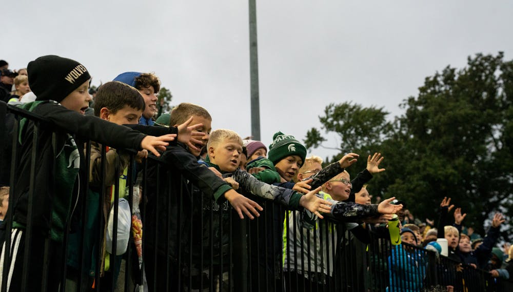 <p>Kids try and catch the free giveaway t-shirts at DeMartin Stadium on Sept. 27, 2022. Spartans defeated the Wolverines 2-0. </p>