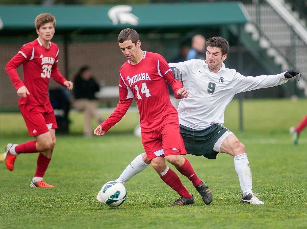 Freshman midfielder Sean Conerty maneuvers around Indiana's Forward T.J. Popolizio on Oct. 28, 2012, at DeMartin Stadium at Old College Field. The Spartans won the game against the Hoosiers 3-1. Natalie Kolb/The State News