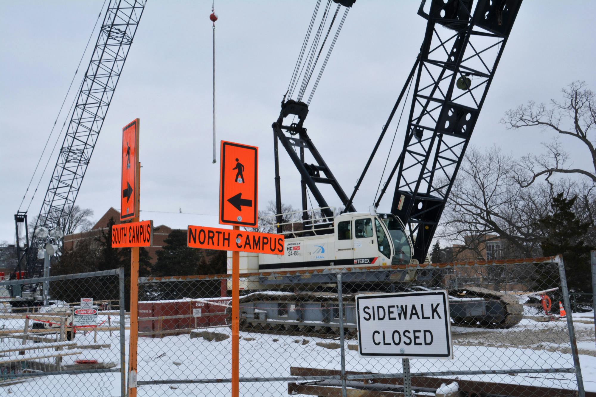 <p>Two large cranes sit behind a fenced-off area of the construction site on Jan. 15, 2024.</p>