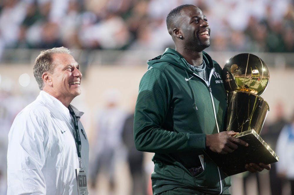 <p>MSU basketball head coach Tom Izzo and former Spartan and current Golden State Warrior forward Draymond Green look out at the crowd during the game against Oregon on Sept. 12, 2015 at Spartan Stadium. Green was recognized for his recent donation to the Spartan basketball program. Alice Kole/The State News</p>