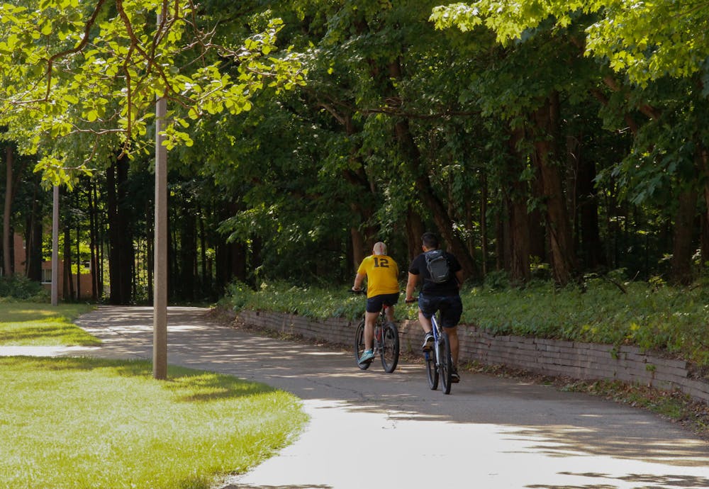 <p>Bikers ride past the Sanford Nature Area in east campus.</p>
