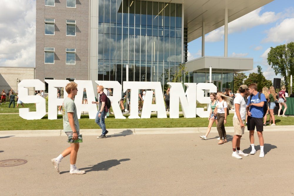 <p>Students walk past 1855 Place during the Spartan Spirit Event and MSU Sparticipation on Aug. 27, 2019. </p>