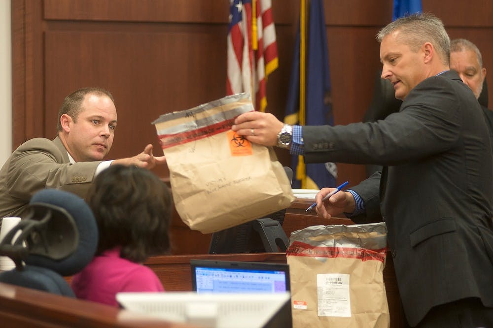 	<p>Deputy Chief Assistant Prosecutor John Dewane, right, hands Sgt. Andrew McCready evidence during the Connor McCowan trial Oct. 10, 2013, at the Ingham County Circuit Court in Lansing. McCowan is on trial for open murder after the Feb. 23 killing of <span class="caps">MSU</span> student Andrew Singler. Julia Nagy/The State News</p>
