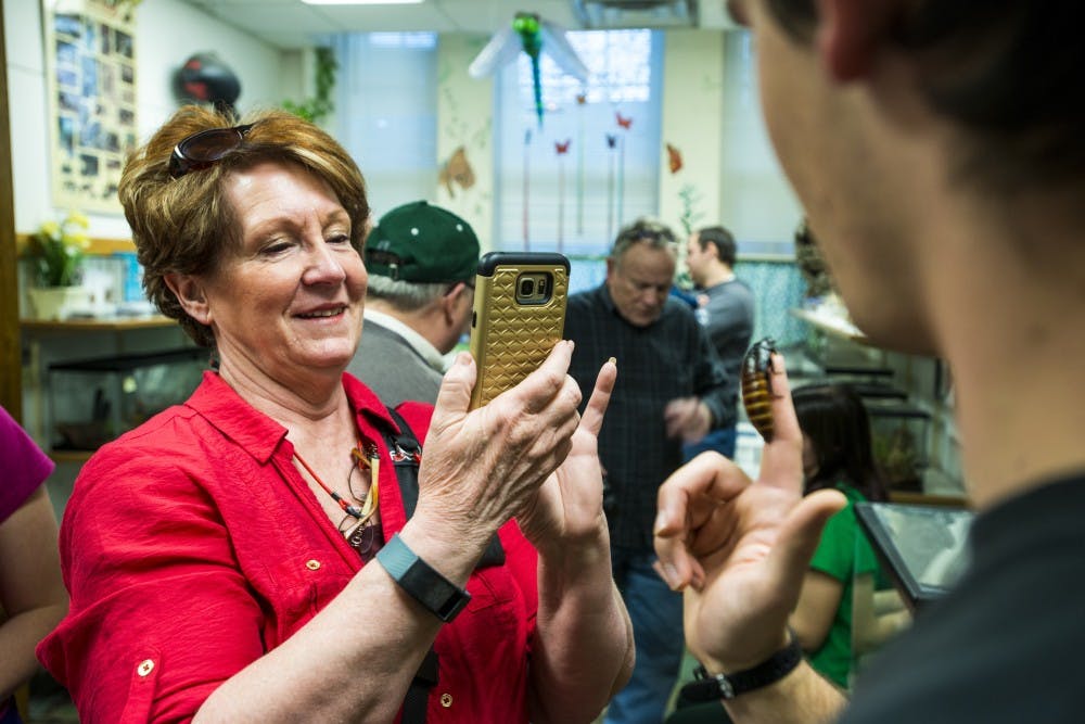 Owosso, Mich. resident Catherine Popowich takes a photo of a Madagascar hissing cockroach during the open house on Feb. 13, 2017 at the Michigan State University Bug House in the Natural Science Building. Popowich said she heard about the bug house through a photographer she is friends with. Popowich also said she is an artist and she takes pictures of wildlife to then draw them.