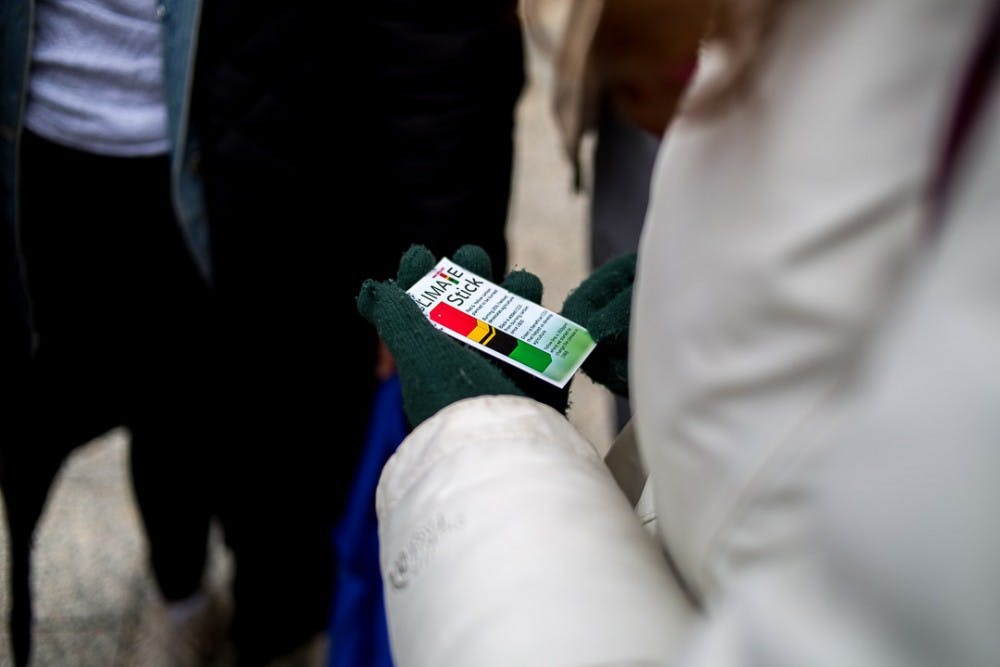 A student reads about a Climate stick during the Global Climate Strike Walkout on March 15, 2019 at the Hannah Administration Building.