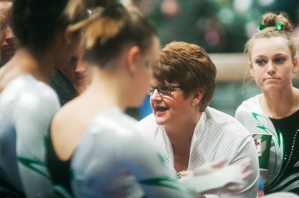 Head coach Kathie Klages tries to pump up the gymnastics team before the uneven bars event  during the meet against U of M on Saturday, March 2, 2013, at Jenison Field House. MSU fell to U of M 197.300-194.875. Danyelle Morrow/The State News