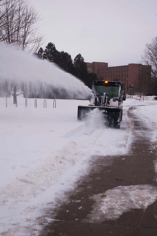 <p>Workers plow the snow Feb. 9, 2015,  to prepare for the school week on MSU's campus. The Infrastructure Planning and Facilities holds the campus's landscape equipment. Hannah Levy/The State News</p>