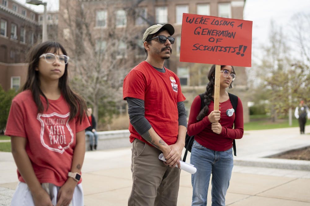 Physics professor Danny Caballero stands with family members during the Stand Up for Higher Education Rally outside the Hannah Administration Building on April 17, 2025.