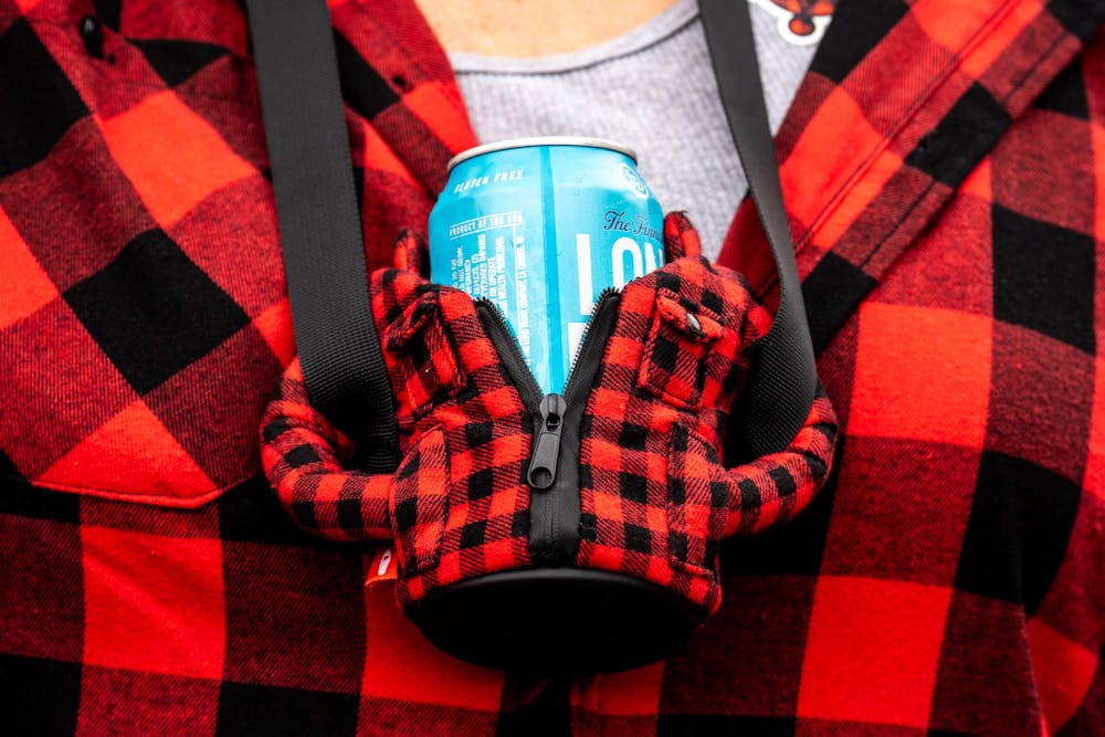 Elizabeth Wray, 59, of Jackson, Mich., stands with a beer koozie during the annual Brrs, Beards & Brews: A Lumberjack Festival in Old Town Lansing, Mich., on Saturday, March 7, 2026.