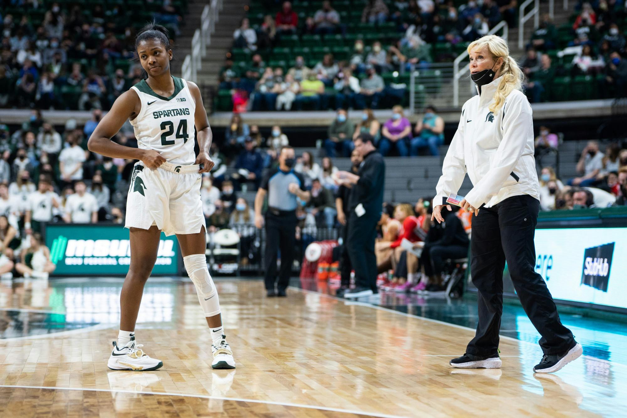 <p>Senior guard Nia Clouden (24) and head coach Suzy Merchant chat during a free throw. The Spartans lost 61-55 against Ohio State University at the Breslin Center on Feb. 27, 2022.</p>