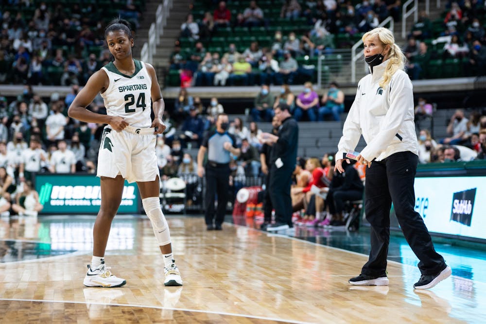 <p>Senior guard Nia Clouden (24) and head coach Suzy Merchant chat during a free throw. The Spartans lost 61-55 against Ohio State University at the Breslin Center on Feb. 27, 2022.</p>