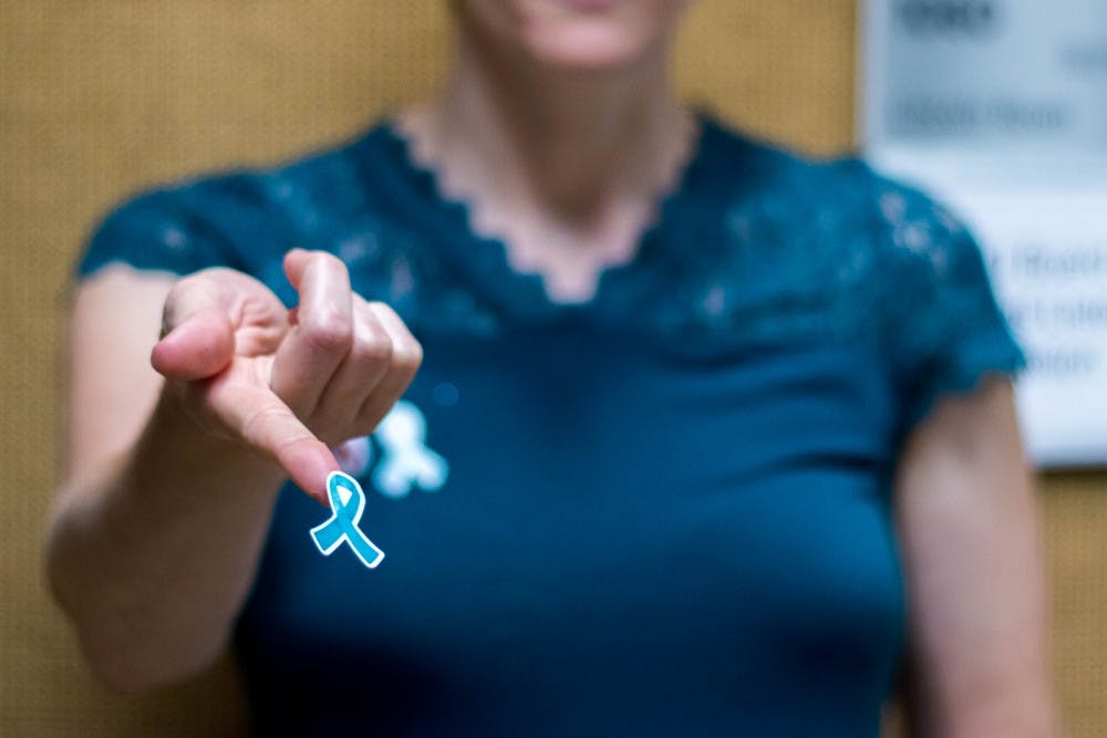 Betsy Riley of Reclaim MSU passes out teal ribbons at the Kellogg Conference Center on Oct. 11, 2018. Teal ribbons are the symbol of support for sexual assault survivors. 