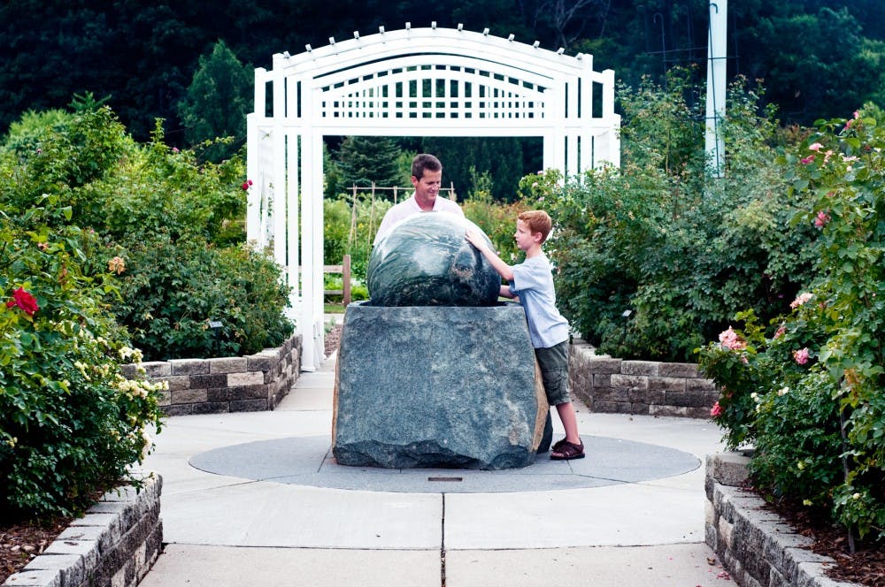 	<p>Bloomfield Hills resident Jack Bahm and his son Jackson, 10, play with a marble stone rolling ball fountain Sunday afternoon in the The Frank?s Nursery and Crafts Rose Garden. Jack and his wife Monica are both graduates of <span class="caps">MSU</span> and decided to take their son on a day trip to campus.</p>