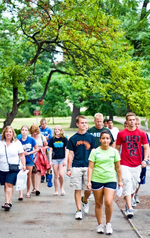 	<p>Wearing green, food industry management senior Leticia Briseno leads potential students on a walking tour Friday through campus stopping at Beaumont Tower, the Red Cedar River and the Rock among other important destinations.  Friday began the annual Green and White Days on campus, which promote <span class="caps">MSU</span> through activities such as academic sessions, student panels and residence hall tours. </p>