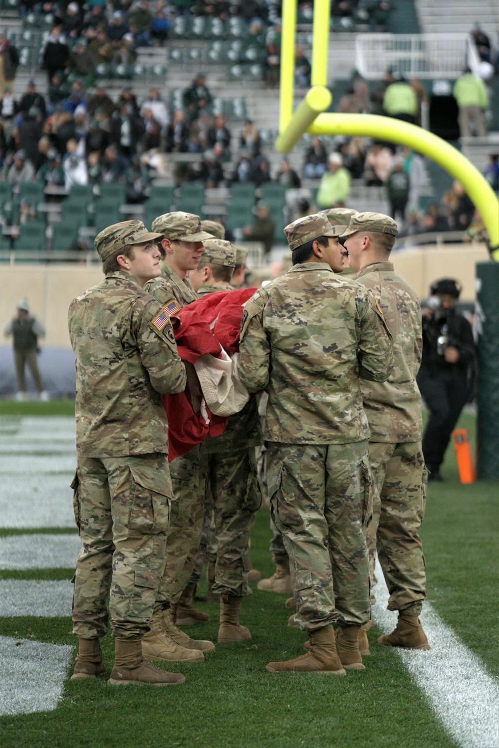 <p>In lieu of Veteran&#x27;s Day, active members ﻿of the army hold the flag on the field during the national anthem before the game began on Nov. 12, 2022.</p>