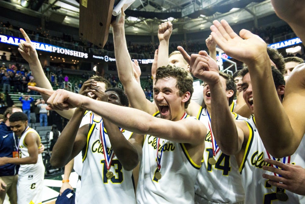 Clarkston?s Foster Loyer (1) celebrates with his team while he holds onto the trophy and points to Clarkston's student section after winning the Class A boys basketball state final game on March 24, 2017 at Breslin Center. Clarkston defeated Grand Rapids Christian, 75-69.