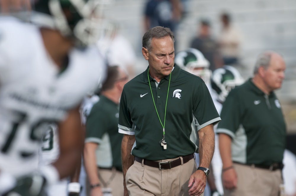 <p>Head coach Mark Dantonio looks over his team during warm-ups on Sept. 4, 2015, before a game against Western Michigan at Waldo Stadium in Kalamazoo, Mich. The Spartans beat the Broncos, 37-24. Julia Nagy/The State News</p>