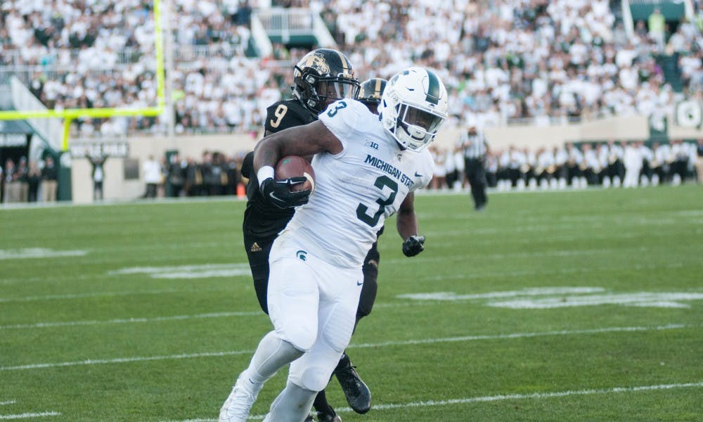 <p>Junior running back LJ Scott (3) runs from Western Michigan defensive back Davontae Ginwright (9) during the game against Western Michigan University on Sep. 9, 2017 at Spartan Stadium. The Spartans defeated the Broncos 28-14.</p>