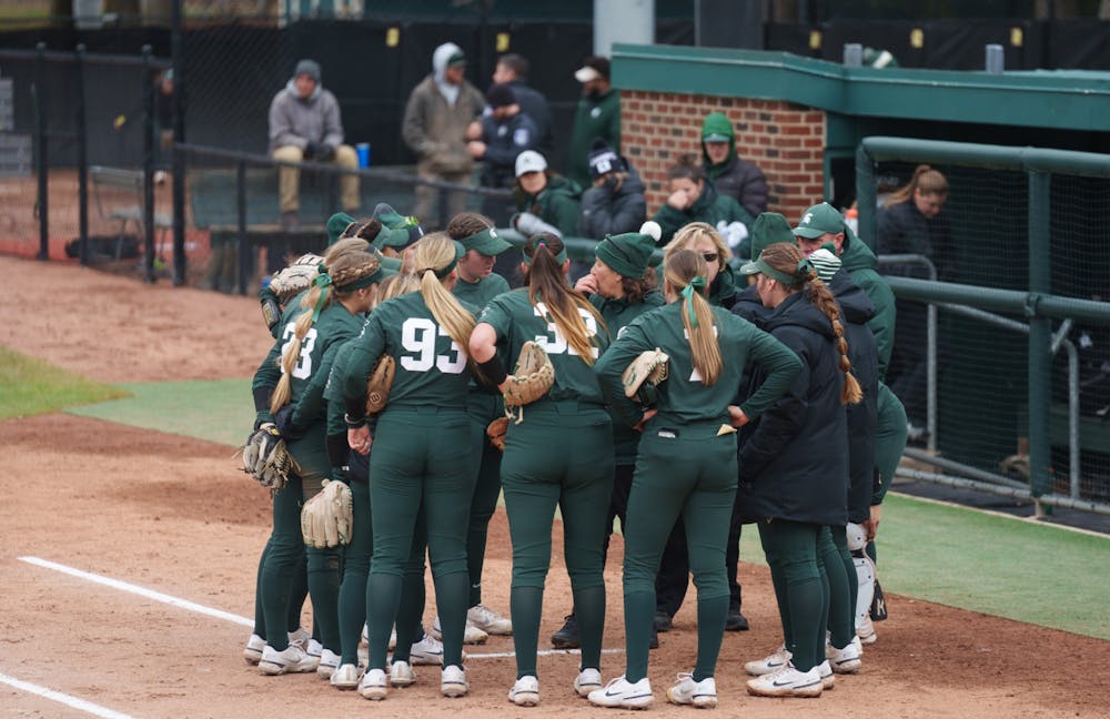<p>Spartans gather around their coaches in the time between the innings. Spartans lost 6-0 against Nebraska, on April 9, 2022.</p>