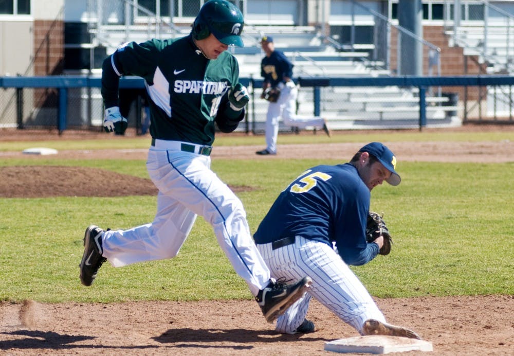 Sophomore third baseman Andrew Carpenter races to beat Michigan first baseman Garrett Stephens to the base Sunday at Ray Fisher Stadium at Wilpon Baseball Complex in Ann Arbor. The Spartans defeated the Wolverines, 5-4. Matt Radick/The State News