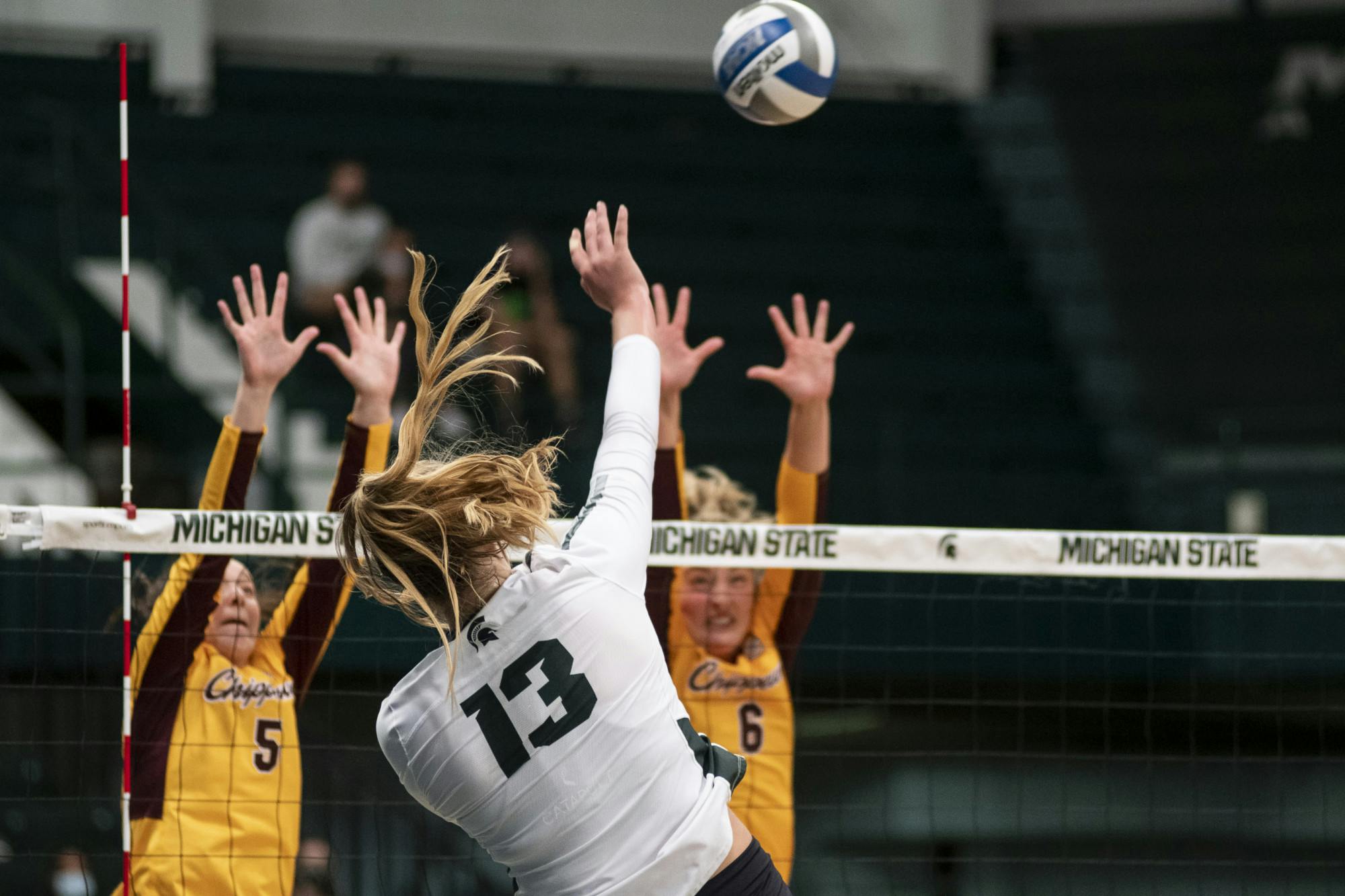 <p>Redshirt freshman Sarah Franklin (13) spikes the ball over the net during the game against Central Michigan University at the Jenison Fieldhouse on Sept. 17, 2021. The Spartans won against the Chippewas 3-1.</p>